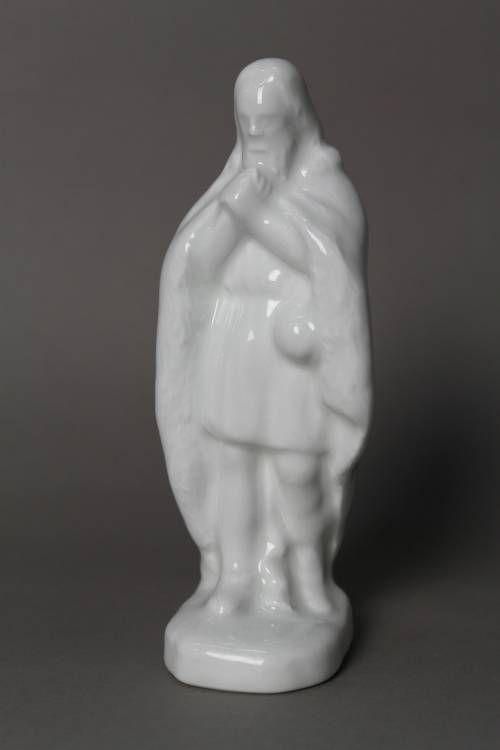 Shepherd with fur coat. Small, white glazed figure.
