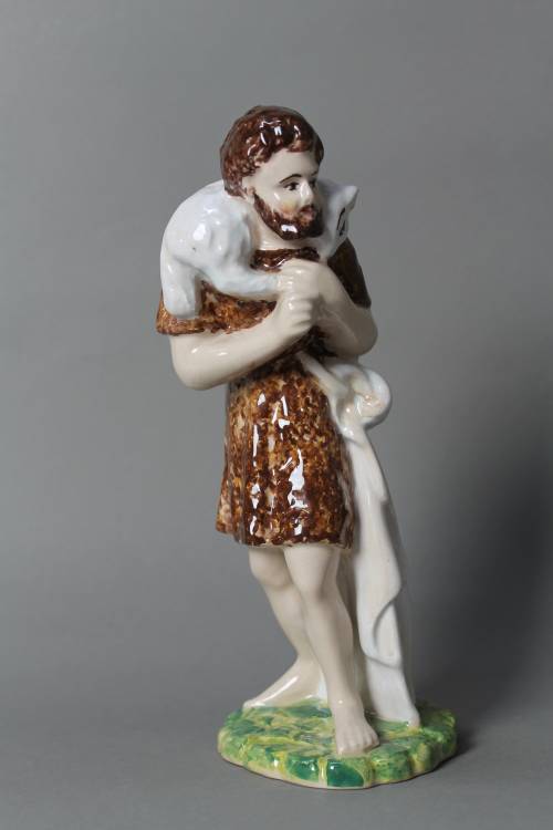 Shepherd with sheep on his shoulders. Large, coloured figure.